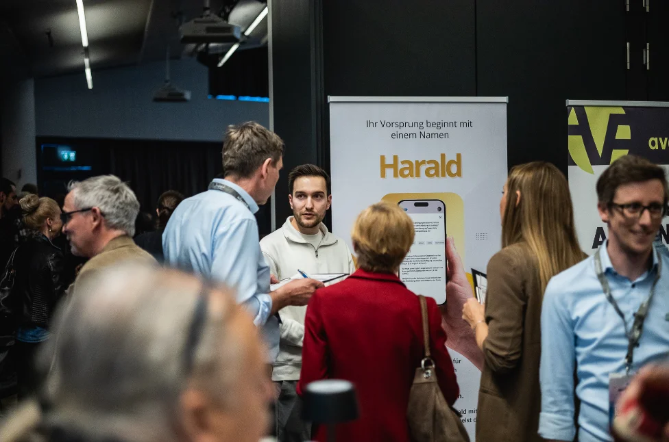 Patrick Stadler im Gespräch mit Besuchern an einem Messestand nach einem Fachvortrag